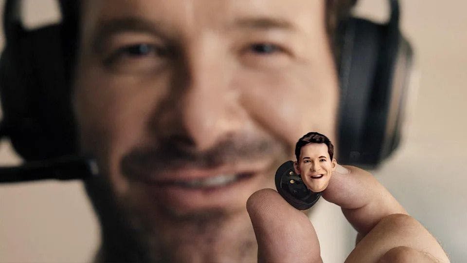 Close up of Tony Romo holding an ear piece with his head on it.